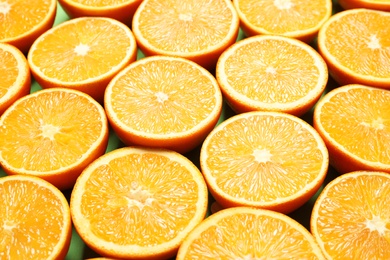 Halves of ripe oranges as background, closeup