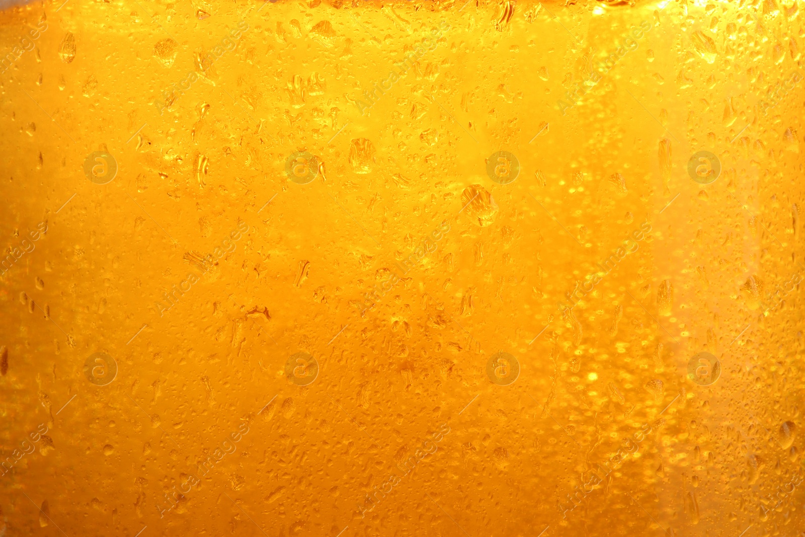 Photo of Glass of tasty cold beer with condensation drops as background, closeup