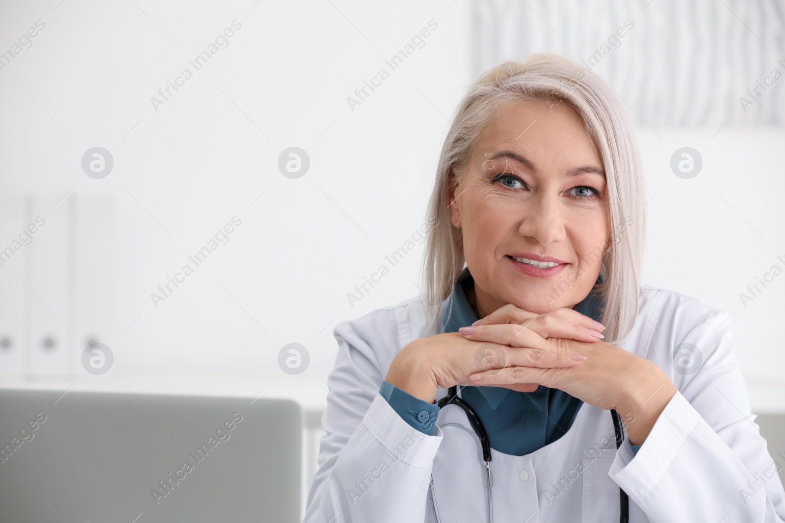 Photo of Portrait of mature female doctor in white coat at workplace