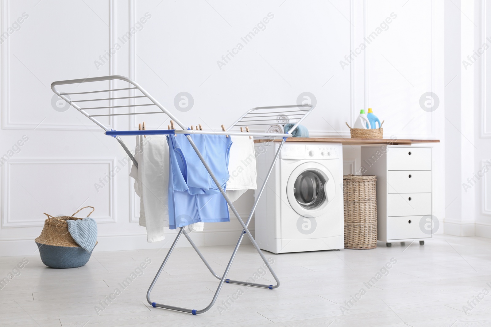 Photo of Clean laundry hanging on drying rack indoors