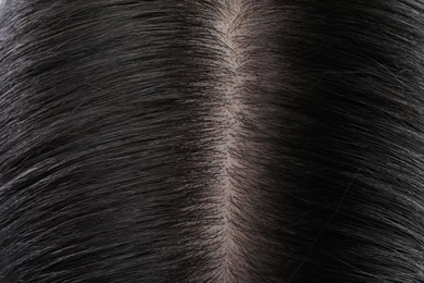 Photo of Closeup view of healthy dark woman`s hair