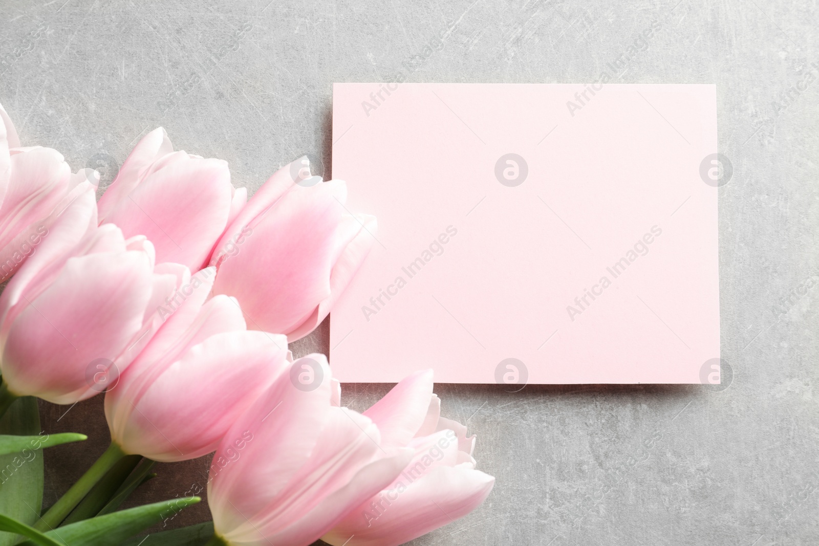 Photo of Beautiful tulips and card for Mother's Day on grey background, top view