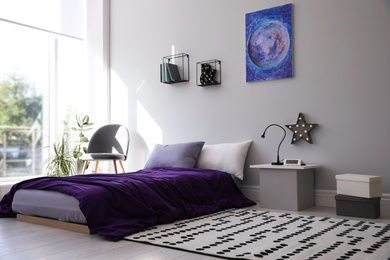 Photo of Modern teenager's room interior with comfortable bed and stylish design elements