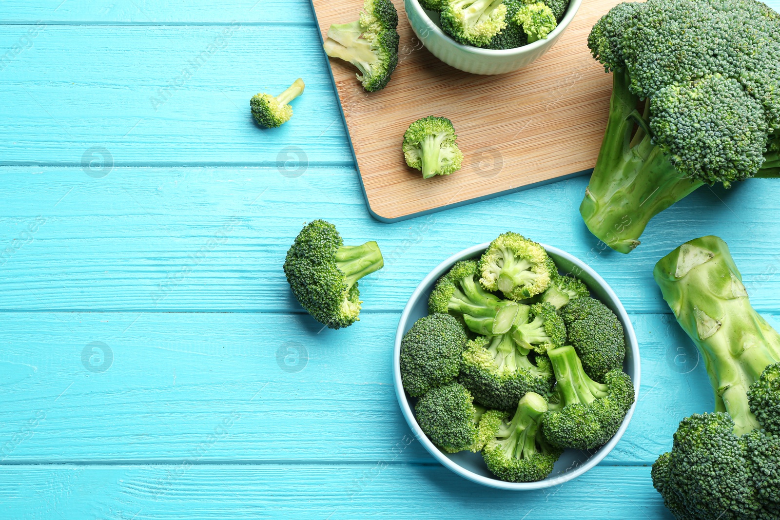 Photo of Flat lay composition of fresh green broccoli on blue wooden table, space for text
