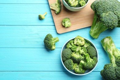 Flat lay composition of fresh green broccoli on blue wooden table, space for text