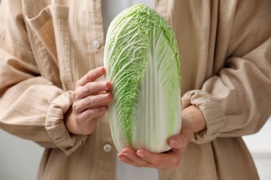 Photo of Woman holding fresh chinese cabbage, closeup view