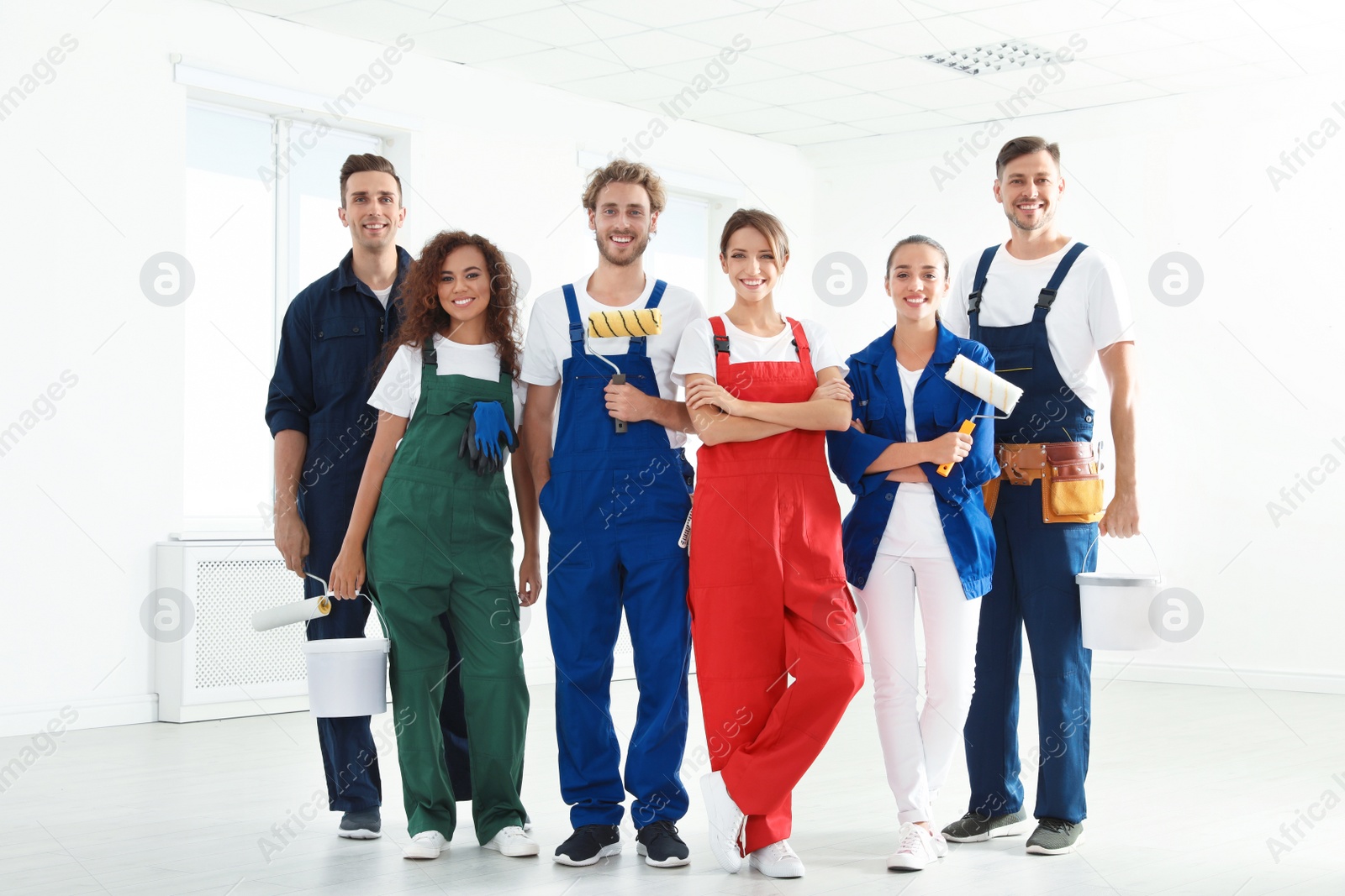 Photo of Team of professional painters with tools indoors