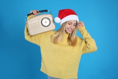 Photo of Happy woman with vintage radio on blue background. Christmas music