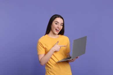 Photo of Smiling young woman with laptop on lilac background