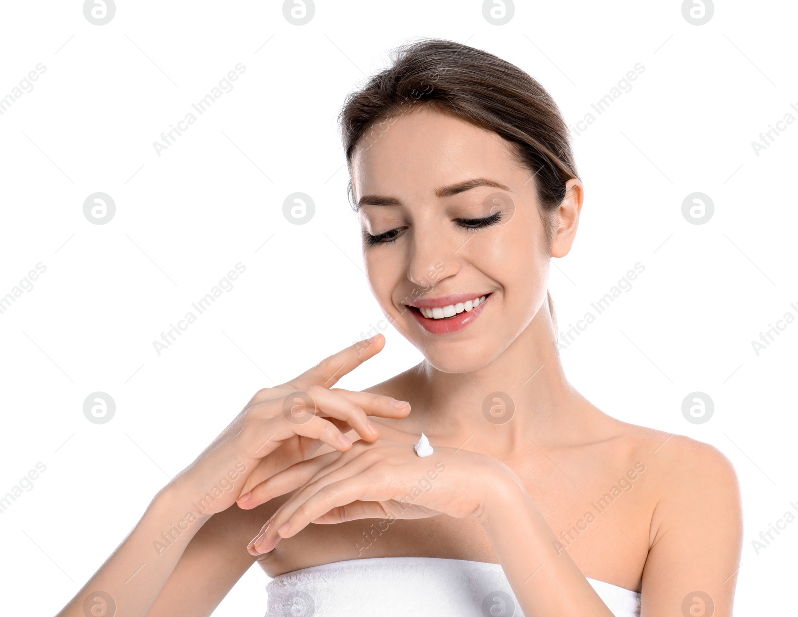 Photo of Young woman applying cream on her hand against white background. Beauty and body care