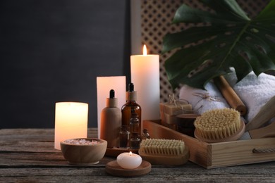 Photo of Composition with different spa products and burning candles on wooden table