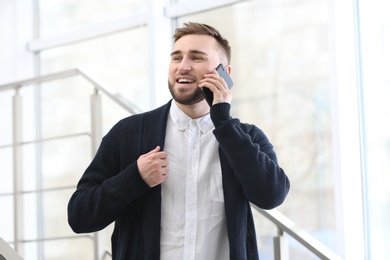 Portrait of confident young man with mobile phone on stairs