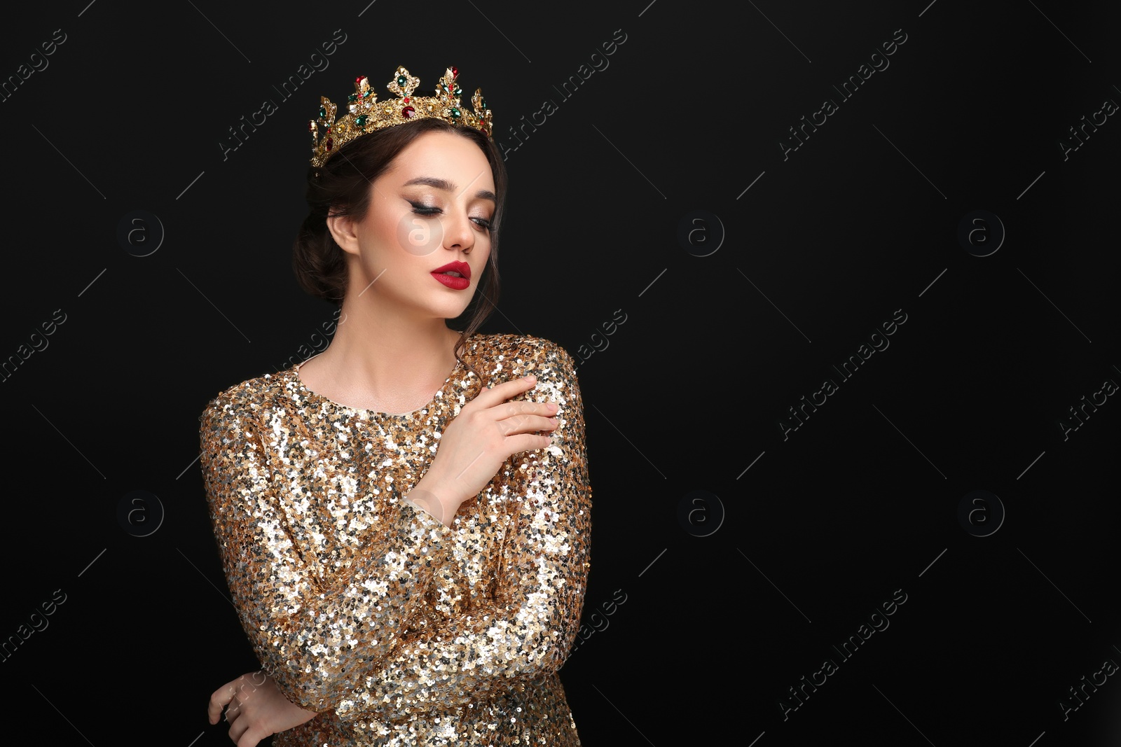 Photo of Beautiful young woman wearing luxurious crown on black background, space for text