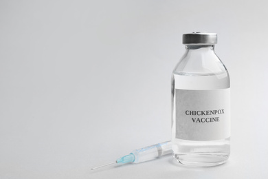 Photo of Chickenpox vaccine and syringe on light grey background, space for text. Varicella virus prevention