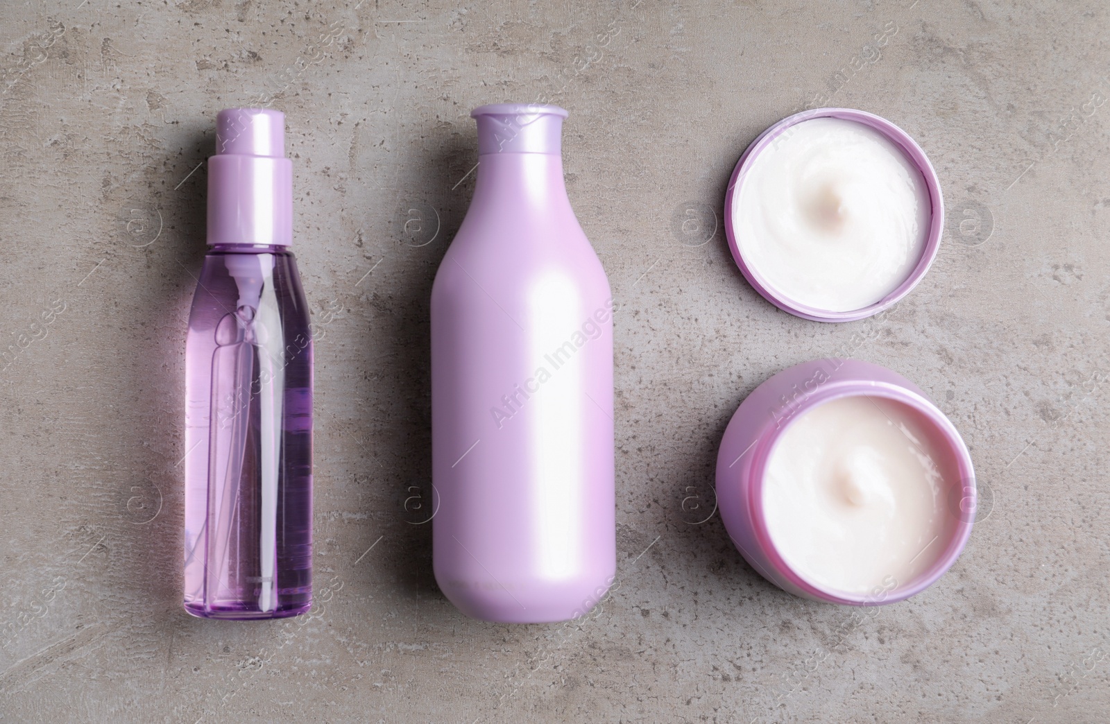 Photo of Flat lay composition with hair cosmetic products on grey stone table