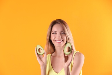 Photo of Portrait of young beautiful woman with ripe delicious avocado on color background