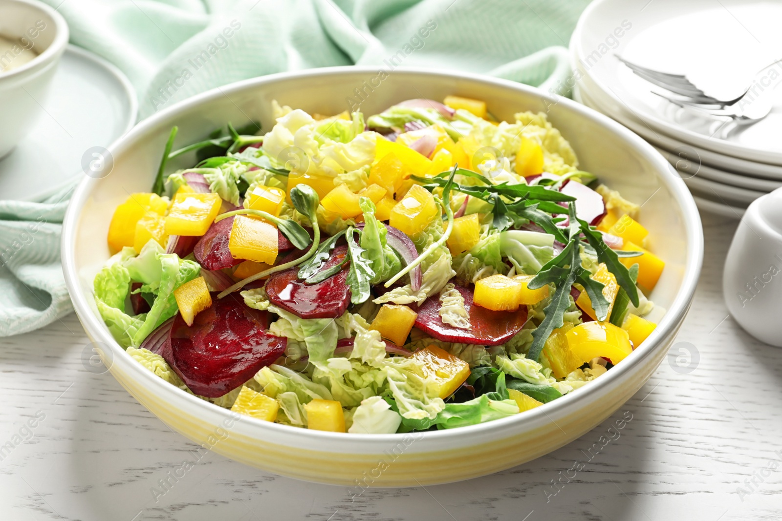 Photo of Bowl with tasty beets salad on table