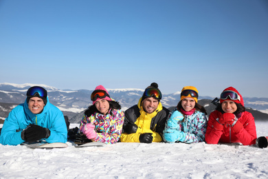 Photo of Group of friends lying on hill. Winter vacation