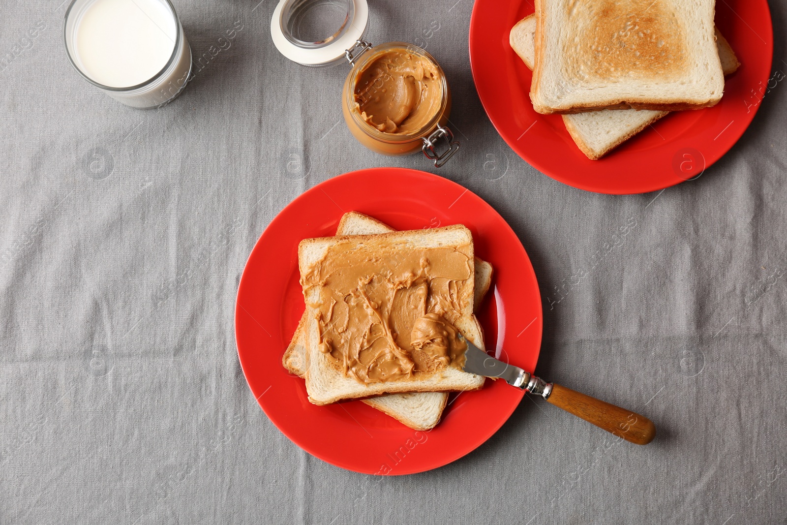 Photo of Flat lay composition with peanut butter and toasts on table