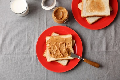 Flat lay composition with peanut butter and toasts on table