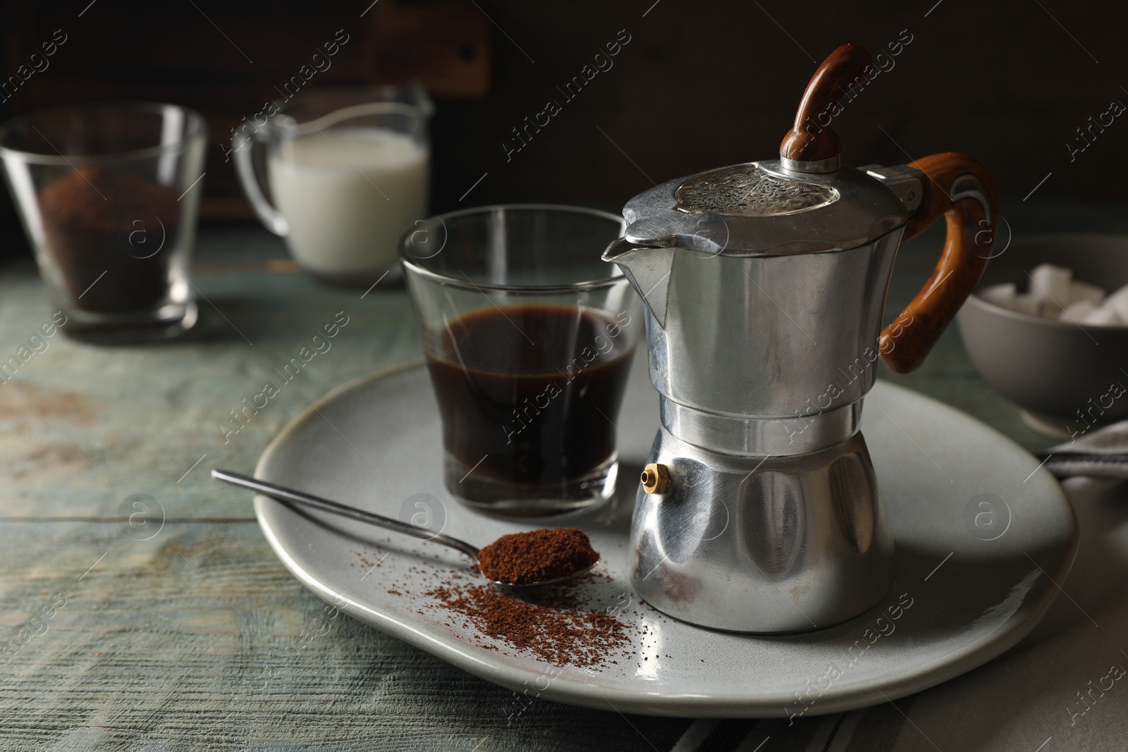 Photo of Brewed coffee in glass and moka pot on rustic wooden table. Space for text