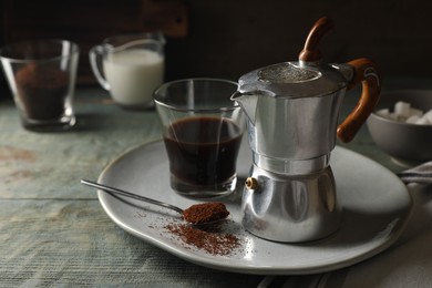 Brewed coffee in glass and moka pot on rustic wooden table. Space for text