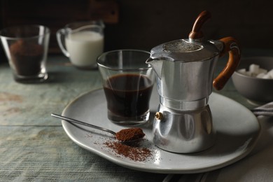 Photo of Brewed coffee in glass and moka pot on rustic wooden table. Space for text