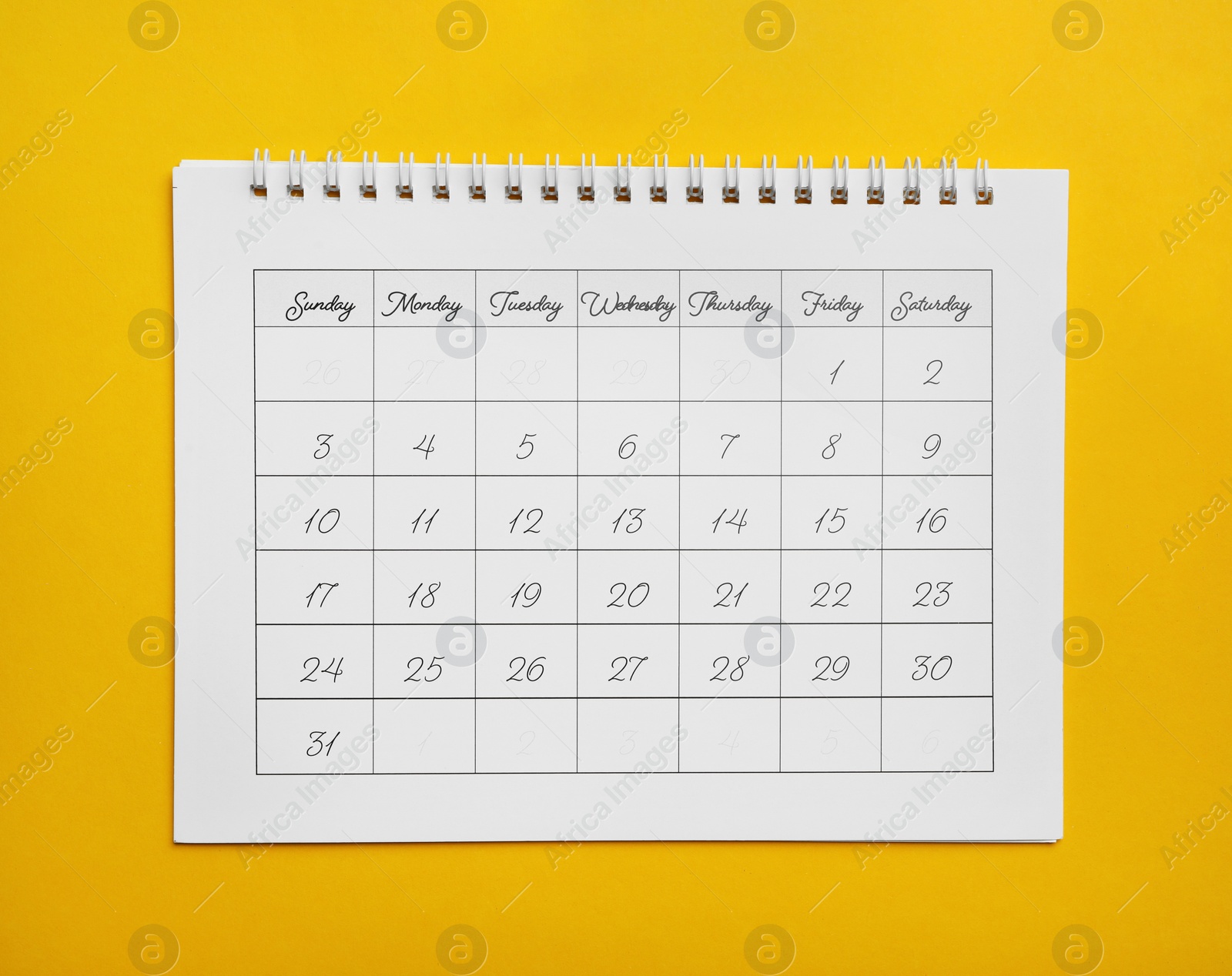 Photo of Paper calendar on yellow background, top view