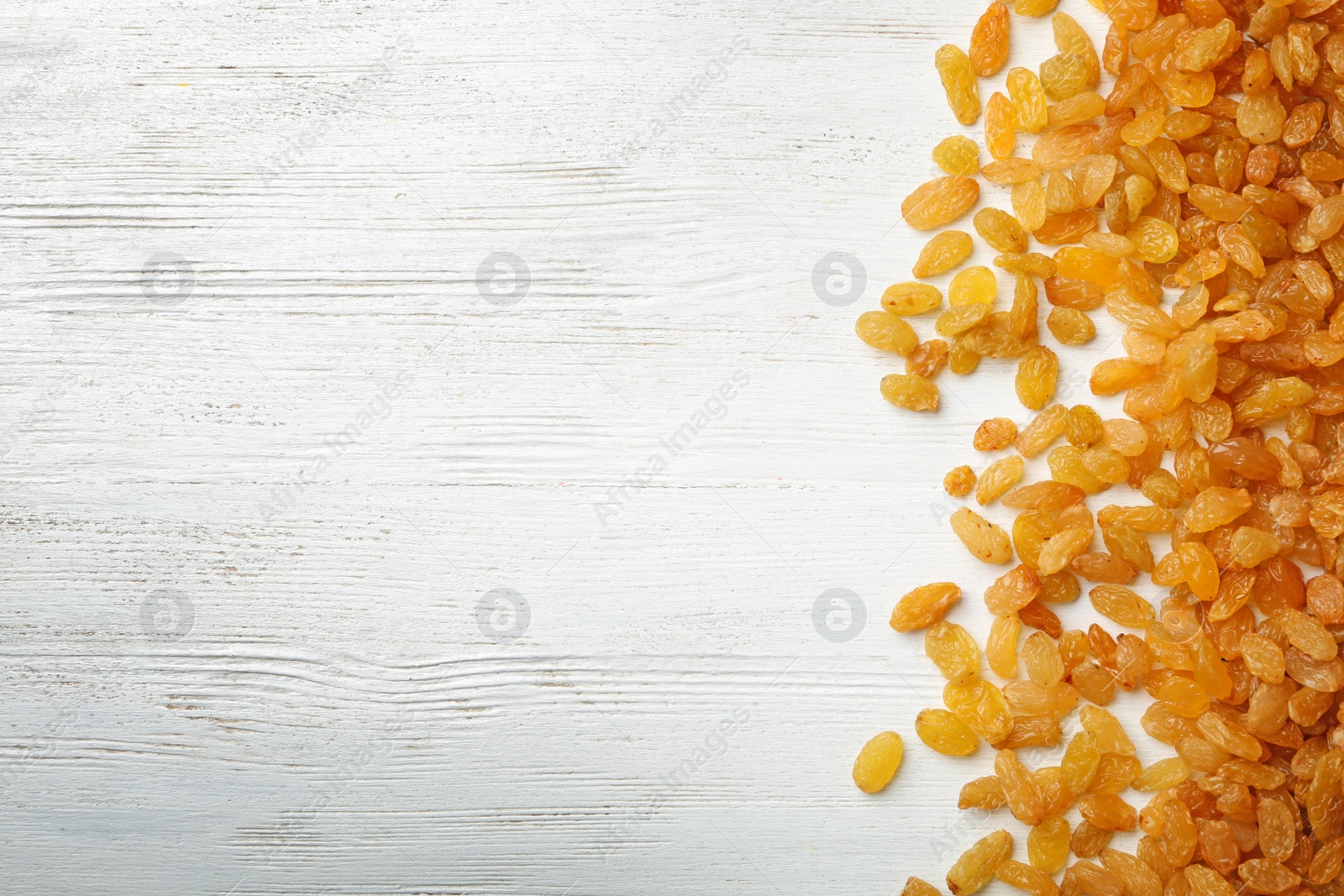 Photo of Raisins on wooden background, top view with space for text. Dried fruit as healthy snack