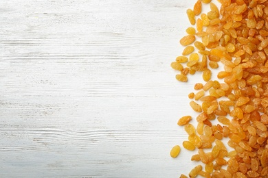 Raisins on wooden background, top view with space for text. Dried fruit as healthy snack