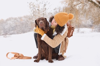 Photo of Woman with adorable Labrador Retriever dog in snowy park