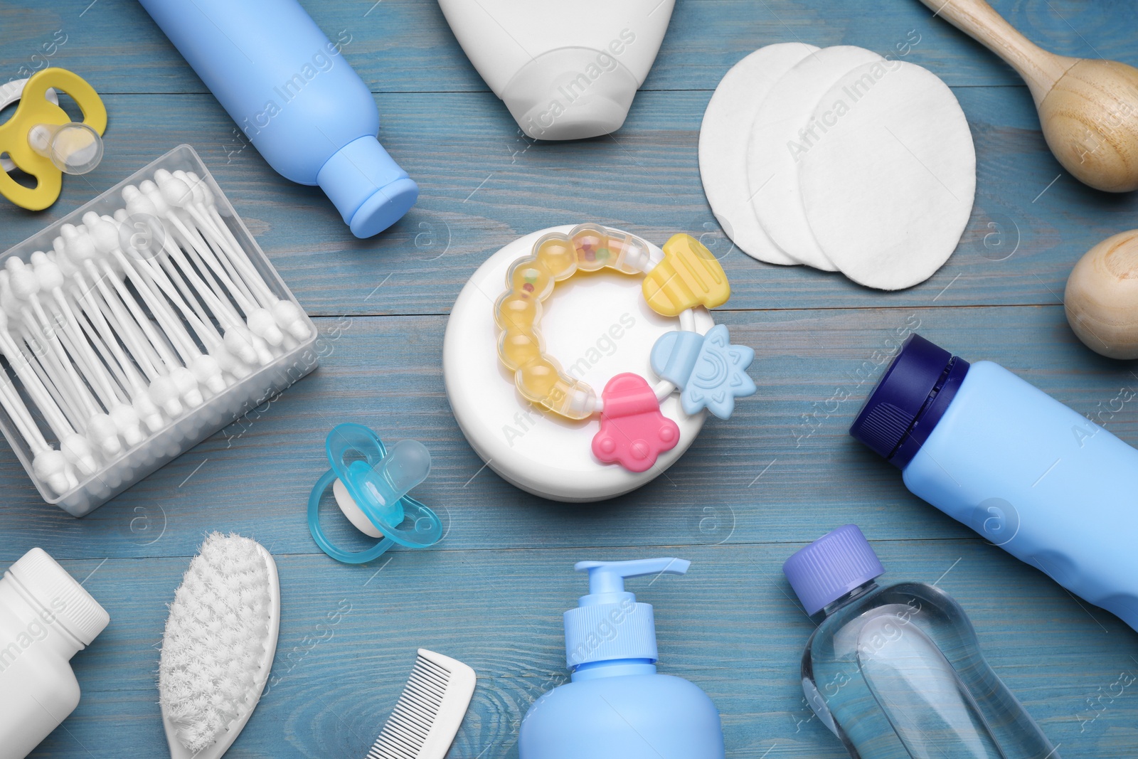 Photo of Flat lay composition with baby care products on light blue wooden table