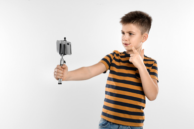 Photo of Cute little blogger recording video on white background