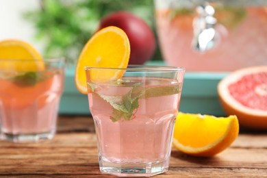 Delicious refreshing drink with orange and mint on wooden table