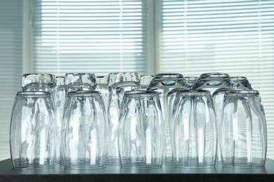 Photo of Empty glasses on grey table against blurred background