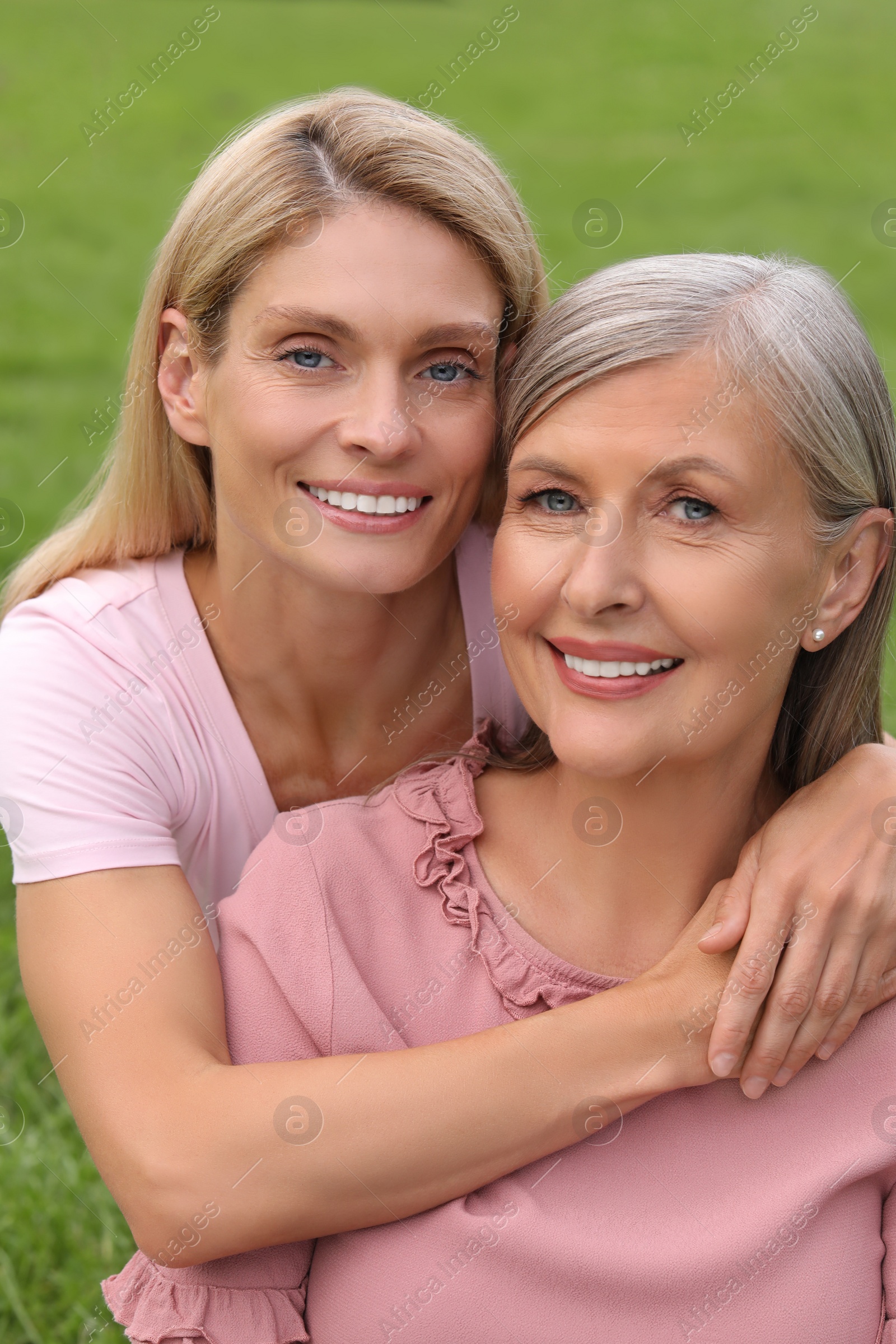 Photo of Happy mature mother and her daughter hugging outdoors