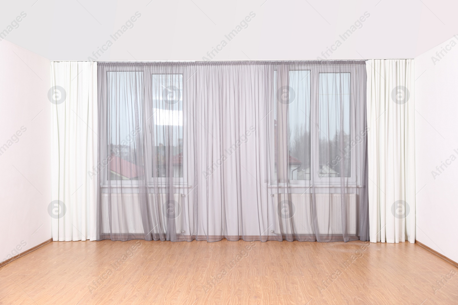 Photo of Windows with elegant curtains in empty room