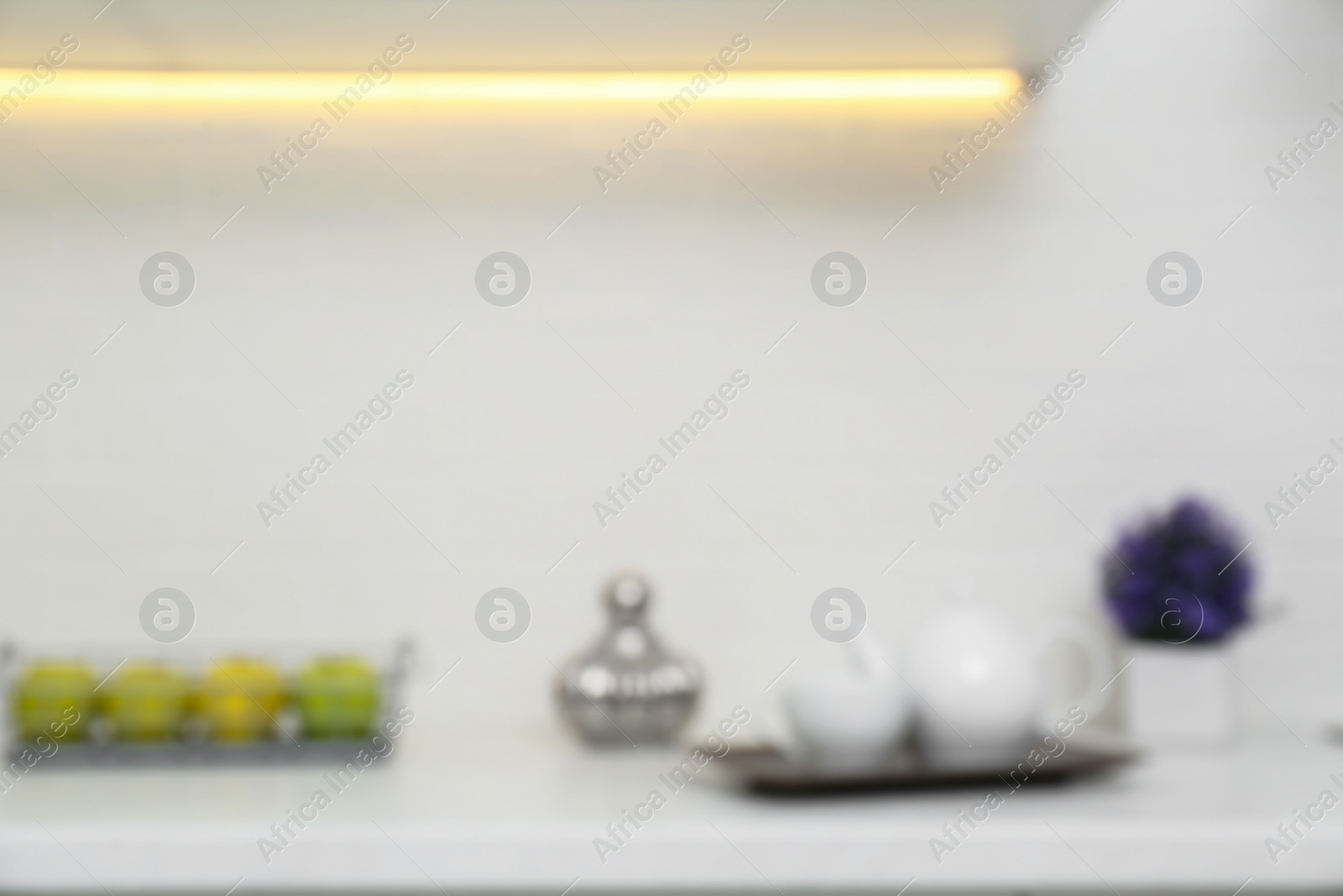 Photo of Blurred view of modern kitchen with white wall