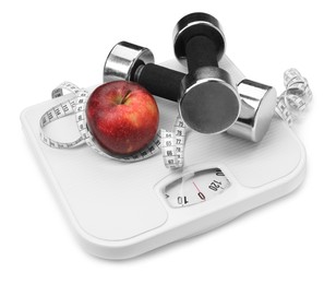 Photo of Scales, apple, measuring tape and dumbbells on white background