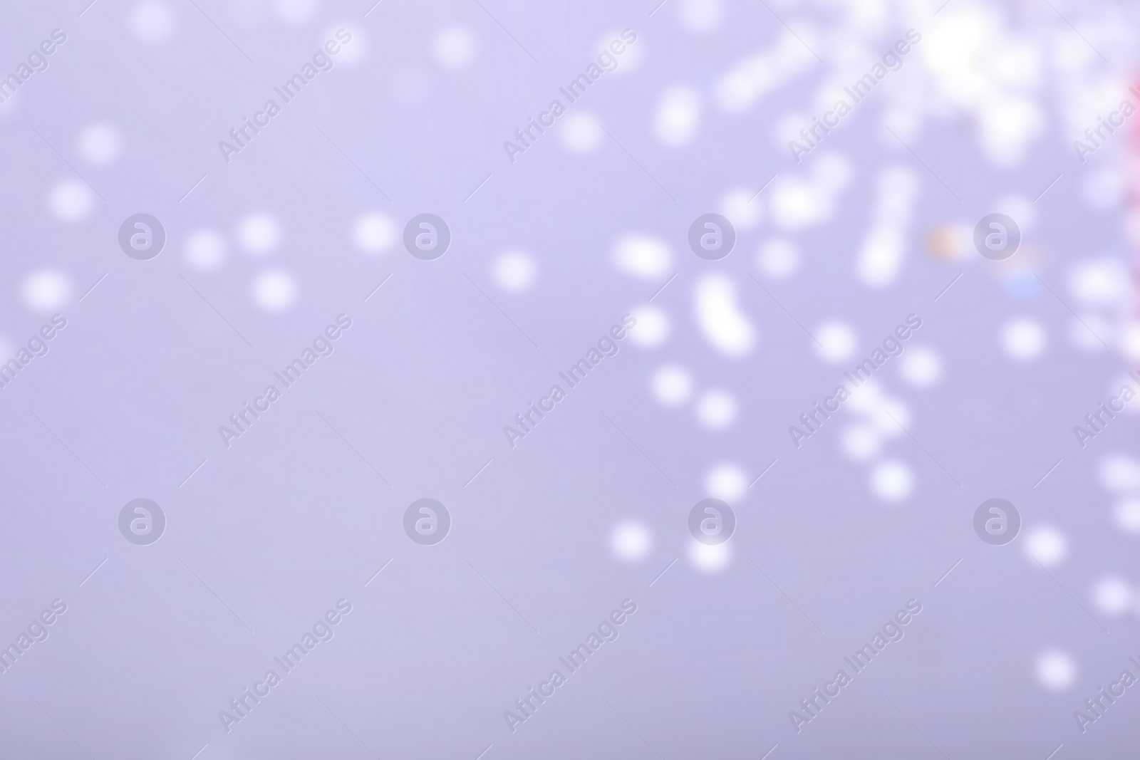Photo of Blurred view of festive lights on violet background. Bokeh effect