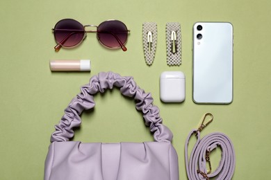 Photo of Flat lay composition with stylish woman's bag on light green background