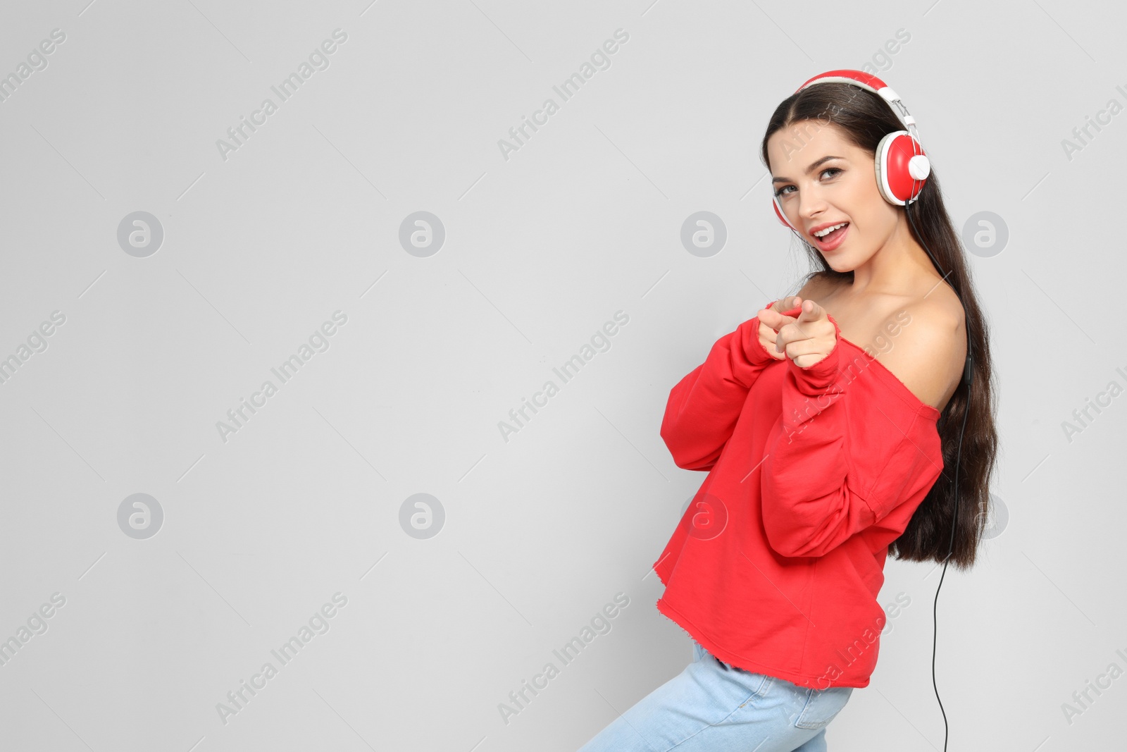 Photo of Young woman listening to Christmas music on color background