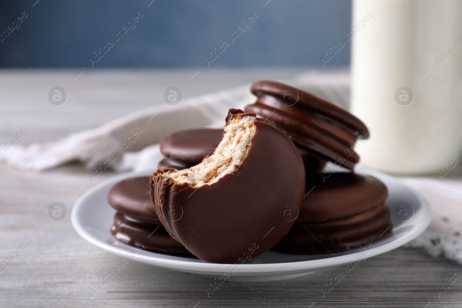 Photo of Tasty choco pies and milk on white wooden table