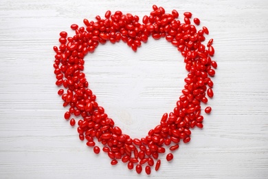 Photo of Frame made of fresh ripe goji berries on white wooden table, flat lay. Space for text