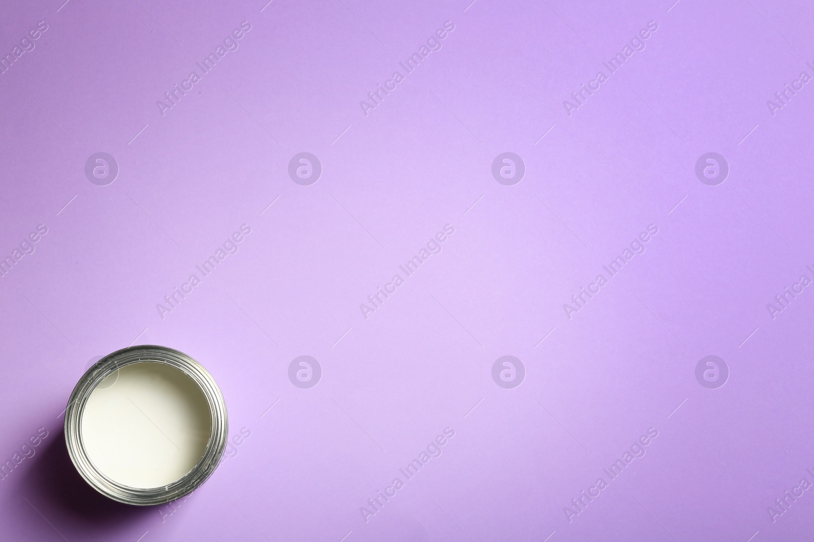 Photo of Open paint can and space for text on color background, top view