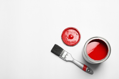 Photo of Paint can and brush on white background, top view. Space for text