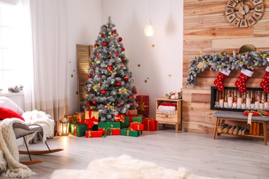 Photo of Stylish room interior with beautiful Christmas tree and decorative fireplace