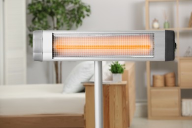 Photo of Modern electric infrared heater in cozy room
