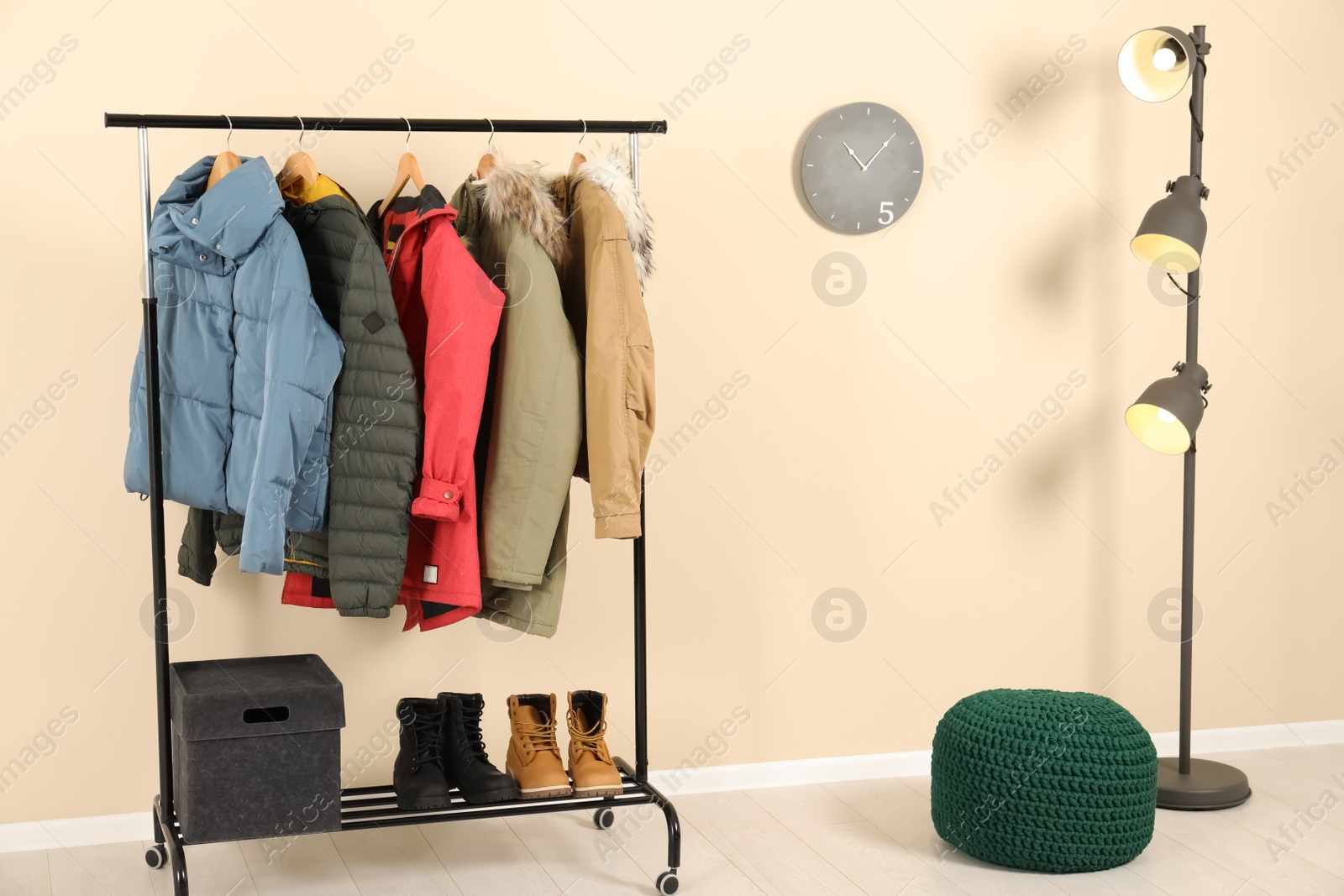 Photo of Stylish hallway interior with clothes on hanger stand