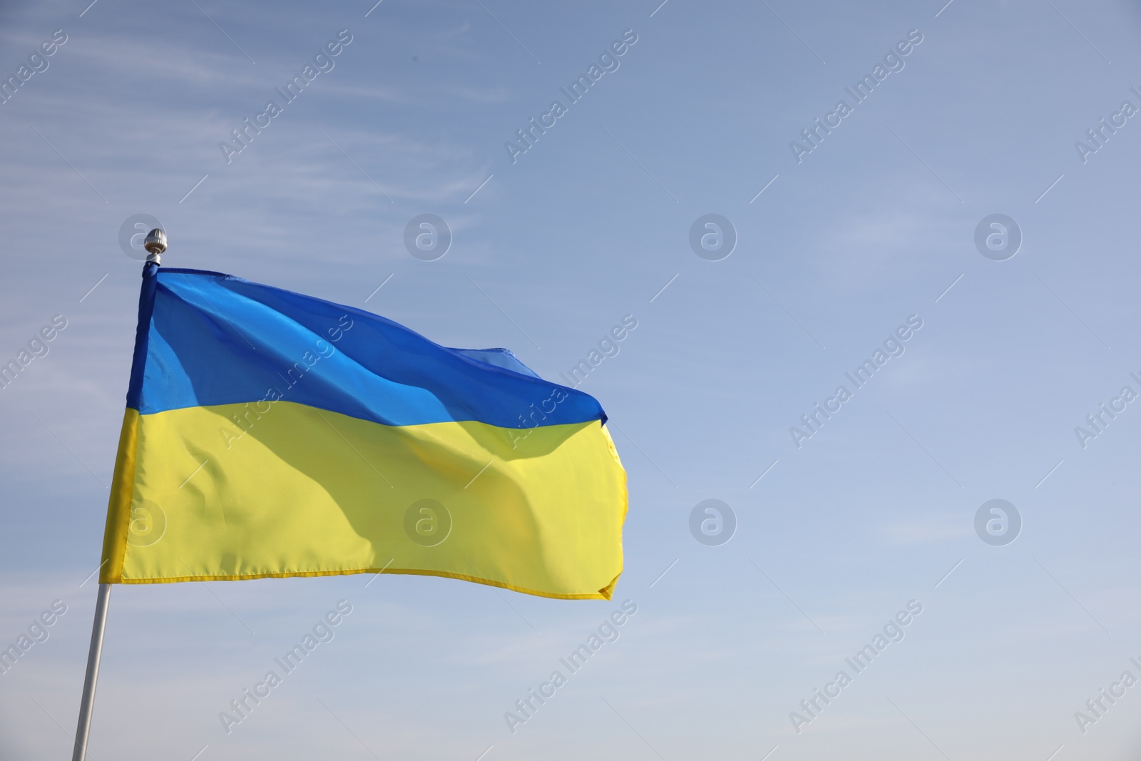 Photo of National flag of Ukraine against blue sky. Space for text